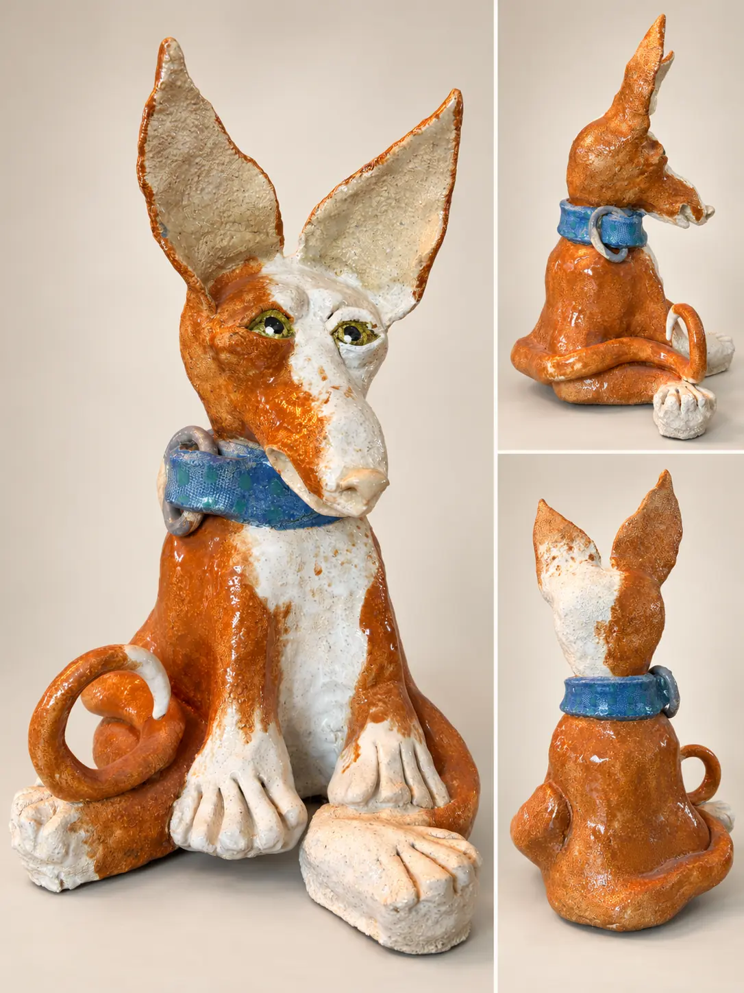 Chien podenco en céramique orange et blanche, aux grandes oreilles et au collier bleu.